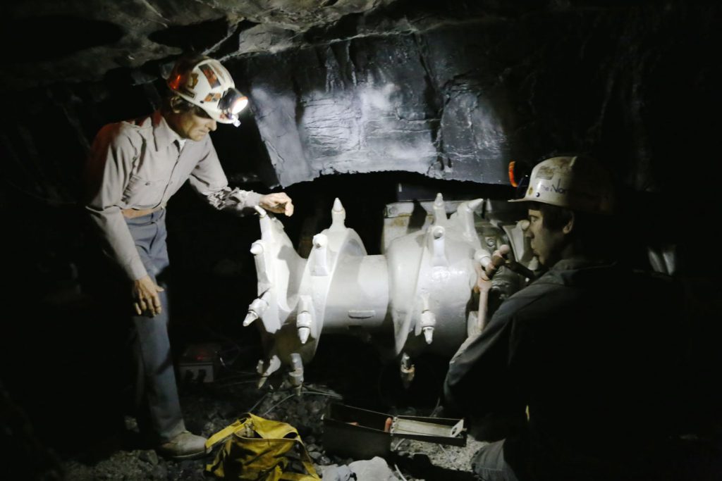 Miners servicing a continuous miner.